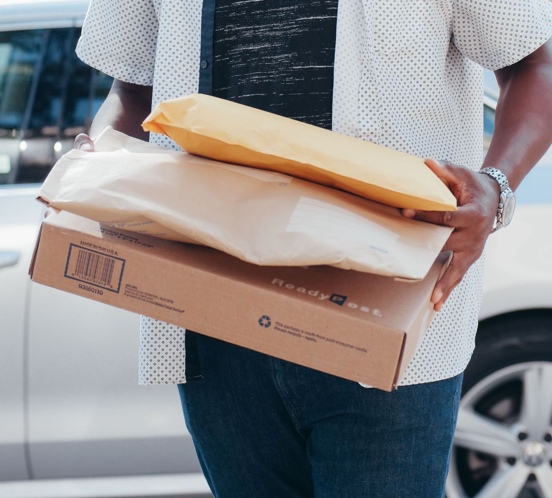 A deliveryman carrying packages outside, showcasing modern online shopping convenience.